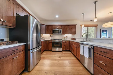a kitchen with granite countertop a refrigerator stove top oven and sink