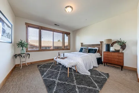 a bedroom with furniture and a large window