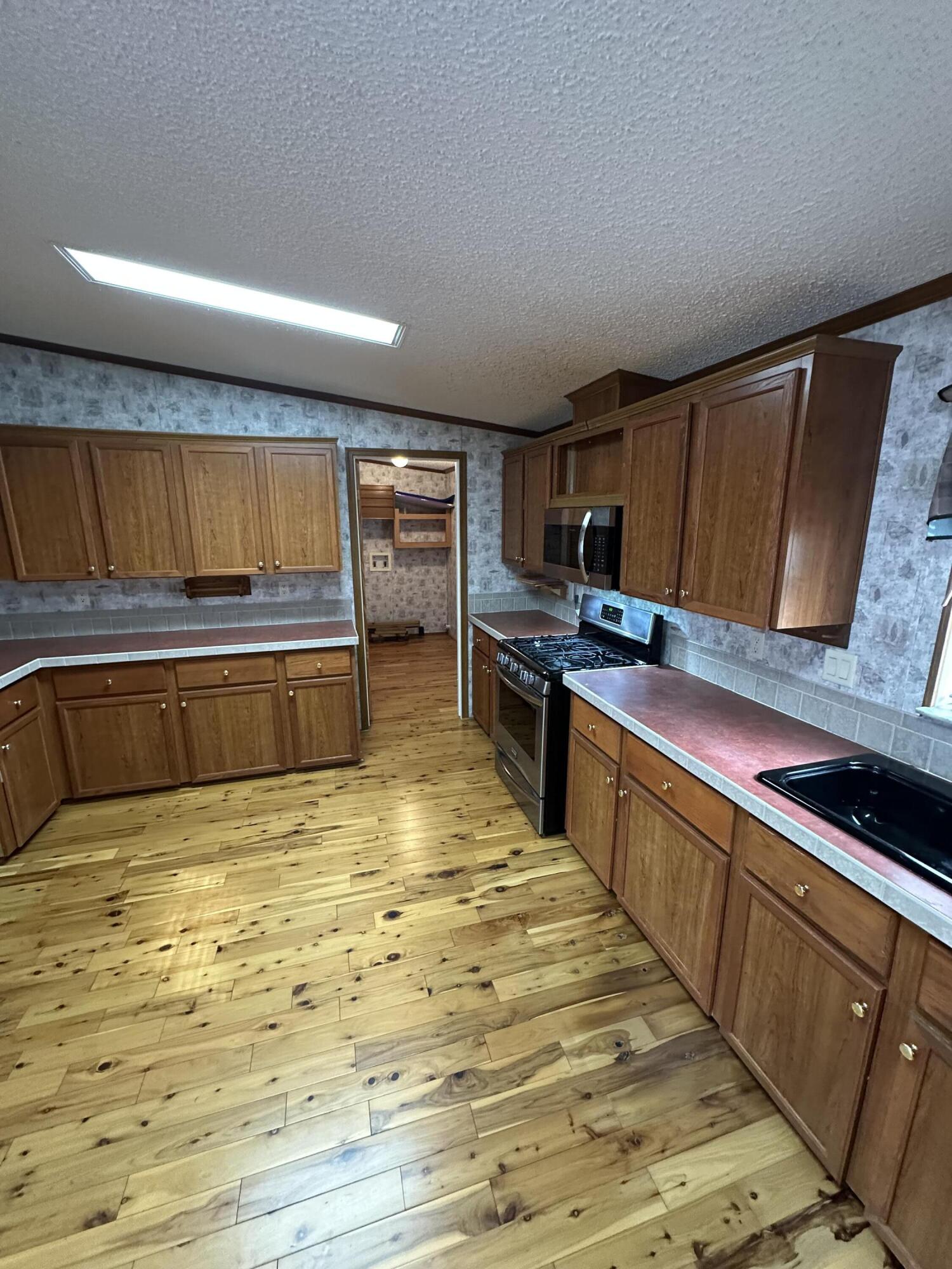 618 Oakridge Road DeFuniak Springs, FL 32433 - Photo 16 of 46 a kitchen with stainless steel appliances granite countertop a stove a sink and a microwave