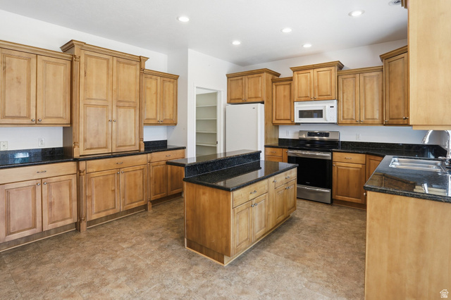 2190 750 West Perry, UT 84302 - Photo 18 of 42 Kitchen with natural wood cabinetry, dark countertops, and stainless steel appliances