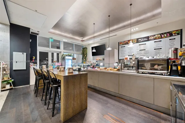 a kitchen with stainless steel appliances granite countertop a table chairs sink and cabinets