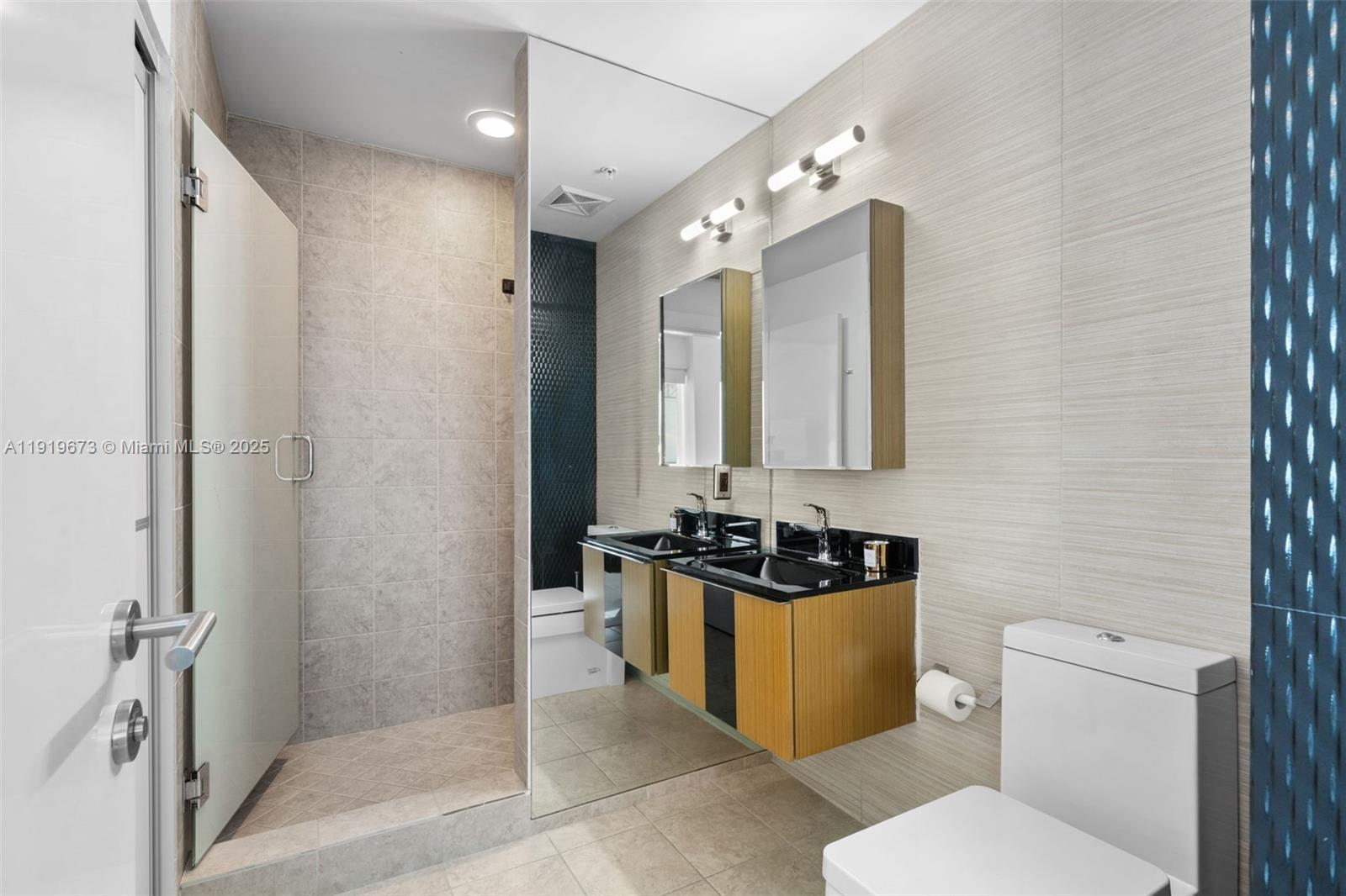 60 Southwest 13th Street, Unit 4606 Miami, FL 33130 - Photo 8 of 28 a bathroom with a toilet sink and mirror