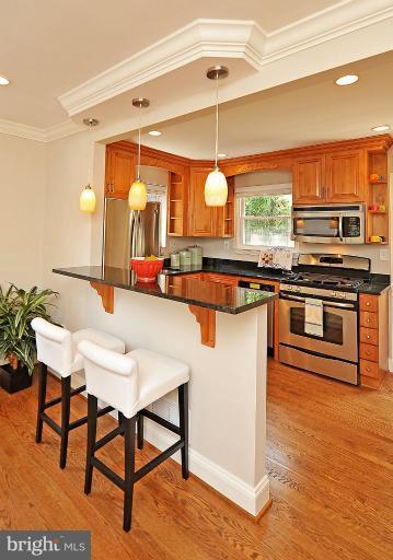 716 West Glebe Road Alexandria, VA 22305 - Photo 22 of 27 a kitchen with stainless steel appliances granite countertop a stove a sink dishwasher and a refrigerator with wooden floor
