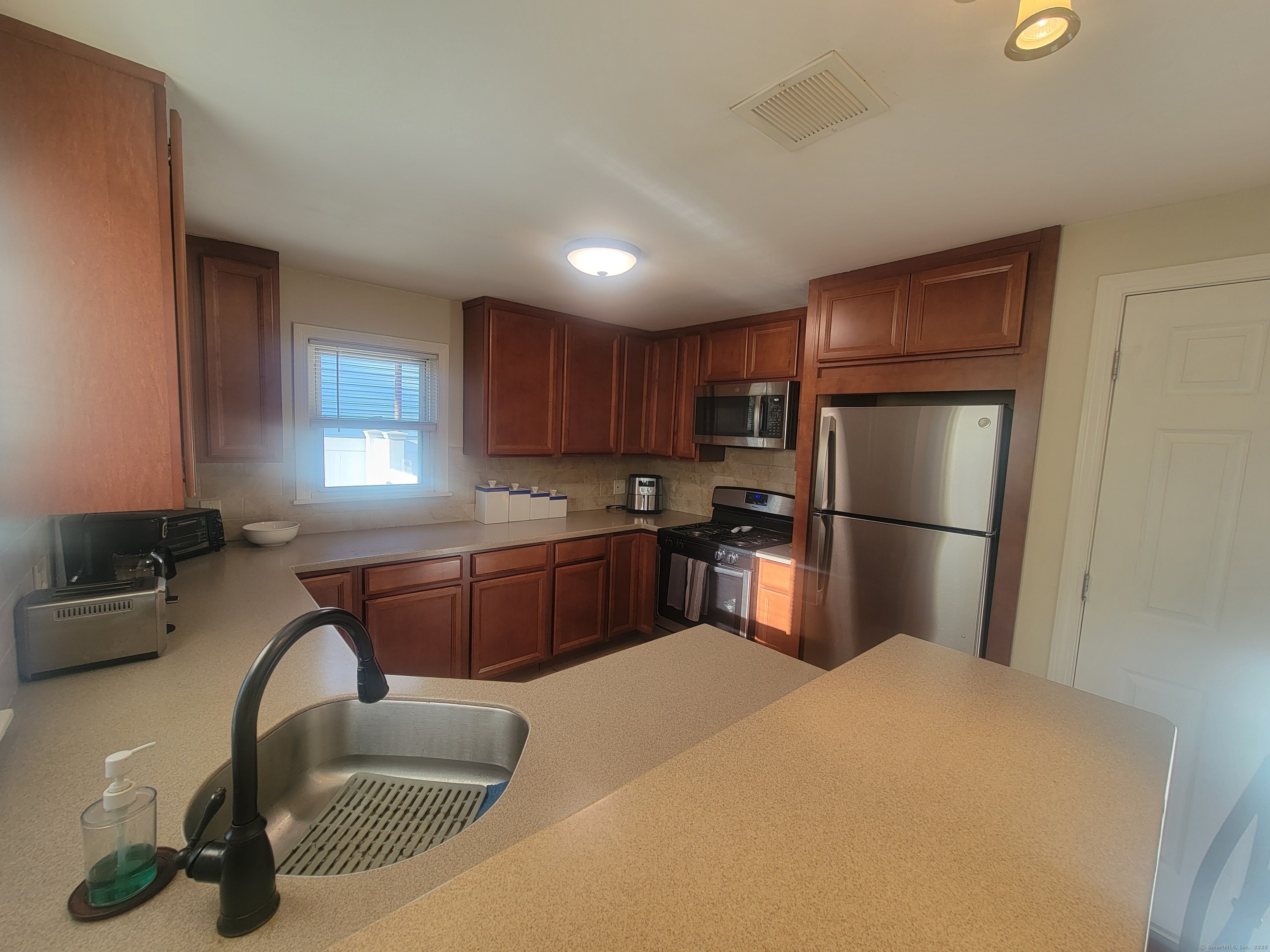 336 Circular Avenue Hamden, CT 06514 - Photo 11 of 21 a kitchen with stainless steel appliances granite countertop a refrigerator sink dishwasher a stove and a refrigerator with wooden cabinets