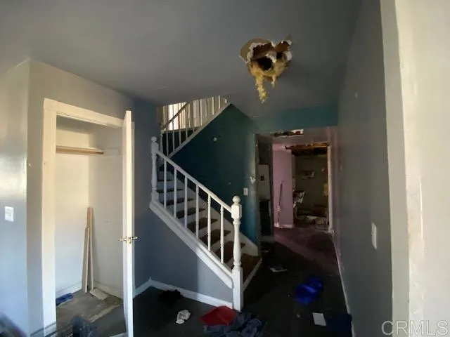 a view of a hallway with entryway and stairs
