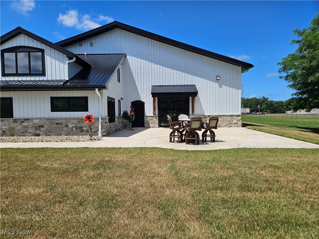 1180 North County Line Road Geneva, OH 44041 - Photo 4 of 33 View of home featuring a patio area, a yard, and stone siding