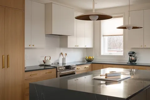 a kitchen with sink a stove and white cabinets