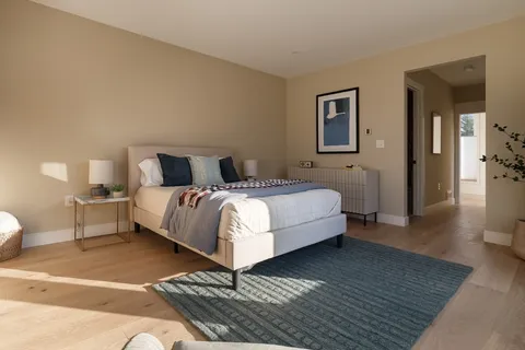 a bedroom with a bed and wooden floor