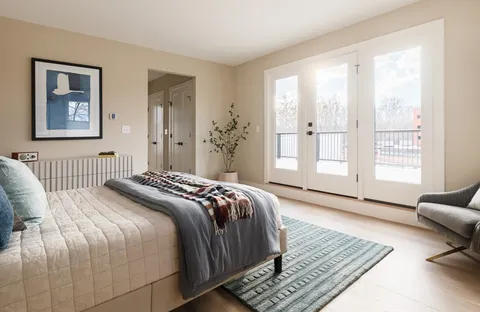 a bedroom with a bed wooden floor and a view of bedroom