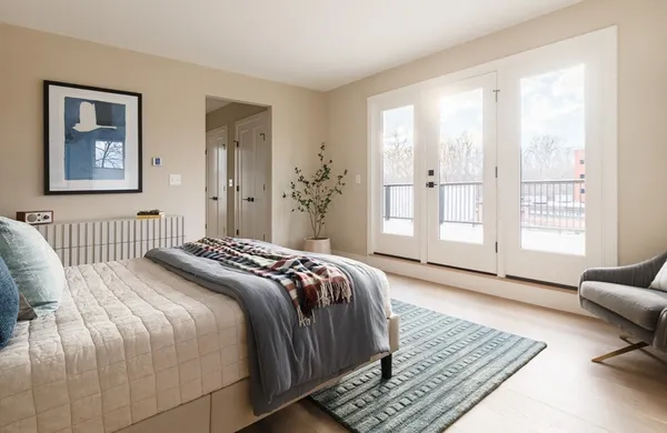 a bedroom with a bed wooden floor and a view of bedroom