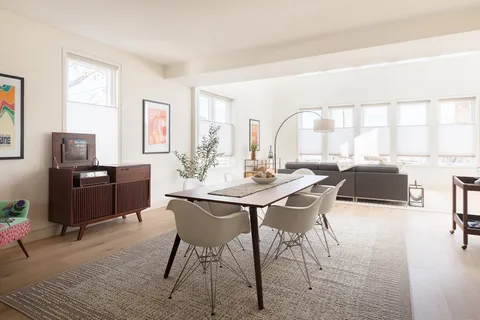 a view of a dining room with furniture and a large window