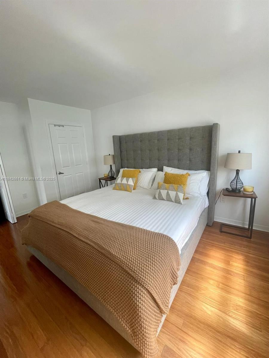 1155 Brickell Bay Drive, Unit 2802 Miami, FL 33131 - Photo 11 of 43 a bedroom with a bed and wooden floor