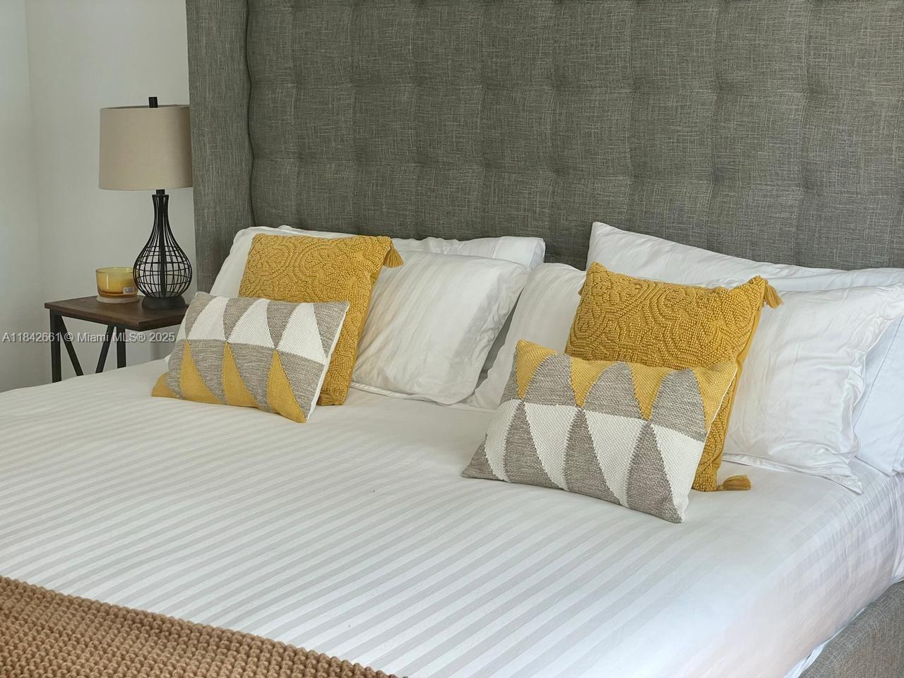 1155 Brickell Bay Drive, Unit 2802 Miami, FL 33131 - Photo 12 of 43 a bed sitting in a bedroom next to a brick wall