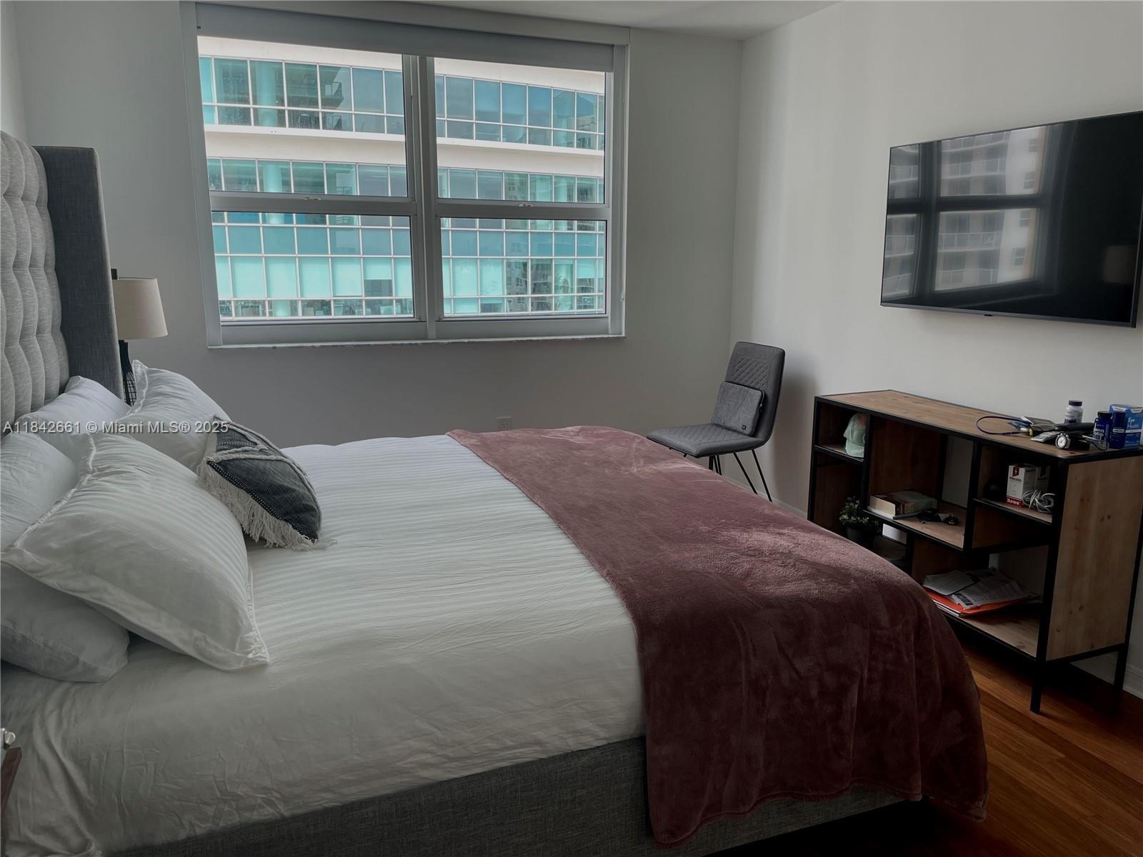 1155 Brickell Bay Drive, Unit 2802 Miami, FL 33131 - Photo 14 of 43 a bedroom with a bed a television and a window