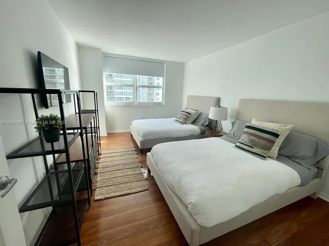 a bedroom with two beds and a window