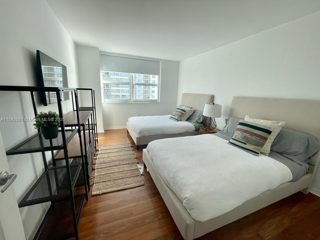 1155 Brickell Bay Drive, Unit 2802 Miami, FL 33131 - Photo 19 of 43 a bedroom with two beds and a window