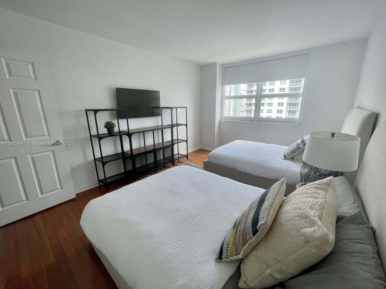 1155 Brickell Bay Drive, Unit 2802 Miami, FL 33131 - Photo 20 of 43 a bedroom with two beds and a window