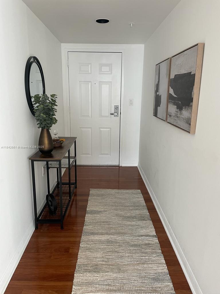 1155 Brickell Bay Drive, Unit 2802 Miami, FL 33131 - Photo 2 of 43 a view of a hallway with wooden floor and entryway