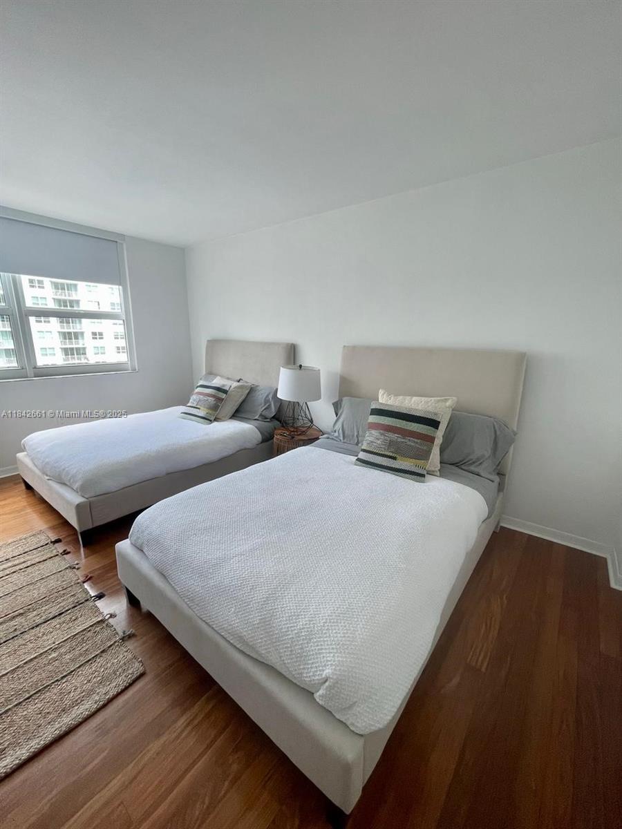 1155 Brickell Bay Drive, Unit 2802 Miami, FL 33131 - Photo 21 of 43 a bedroom with two beds and a night stand