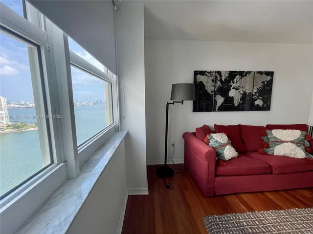 a view of a couch in a living room with wooden floor