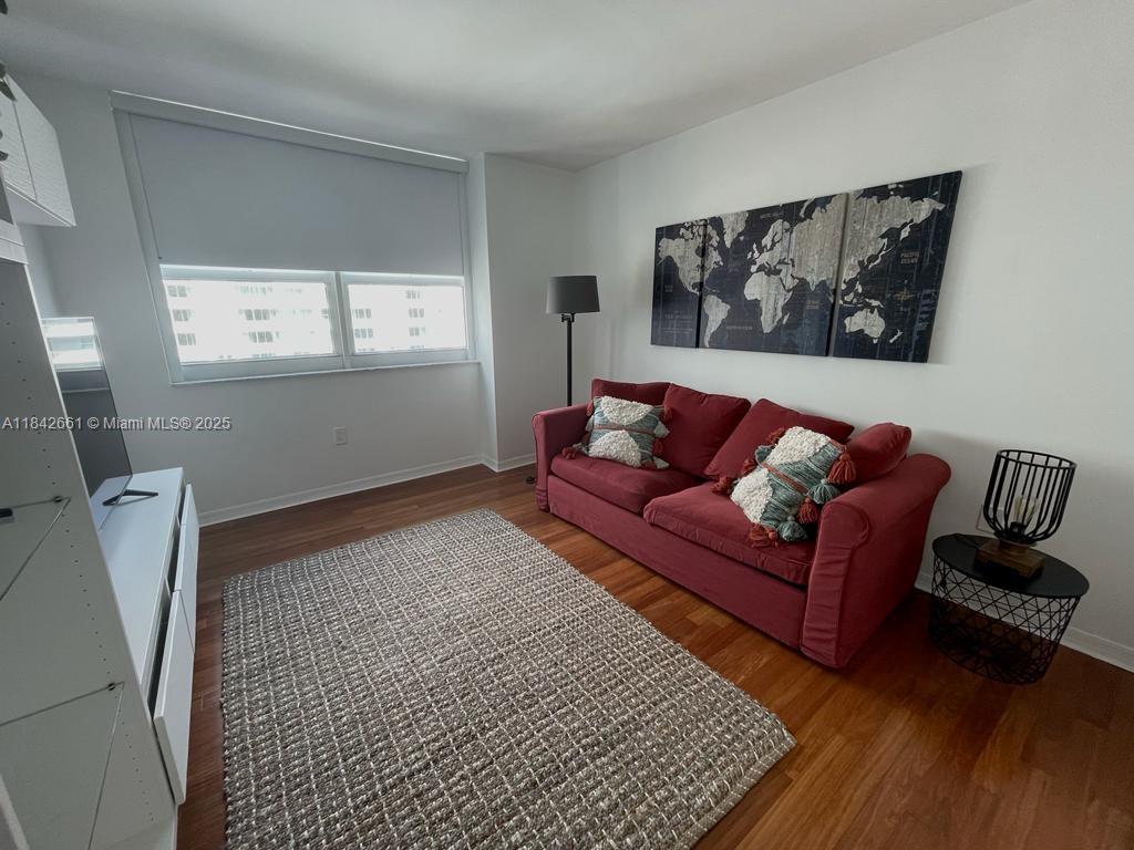 1155 Brickell Bay Drive, Unit 2802 Miami, FL 33131 - Photo 33 of 43 a blue couch sitting in a living room with a rug