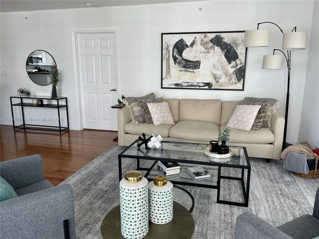 a living room with furniture and a wooden floor