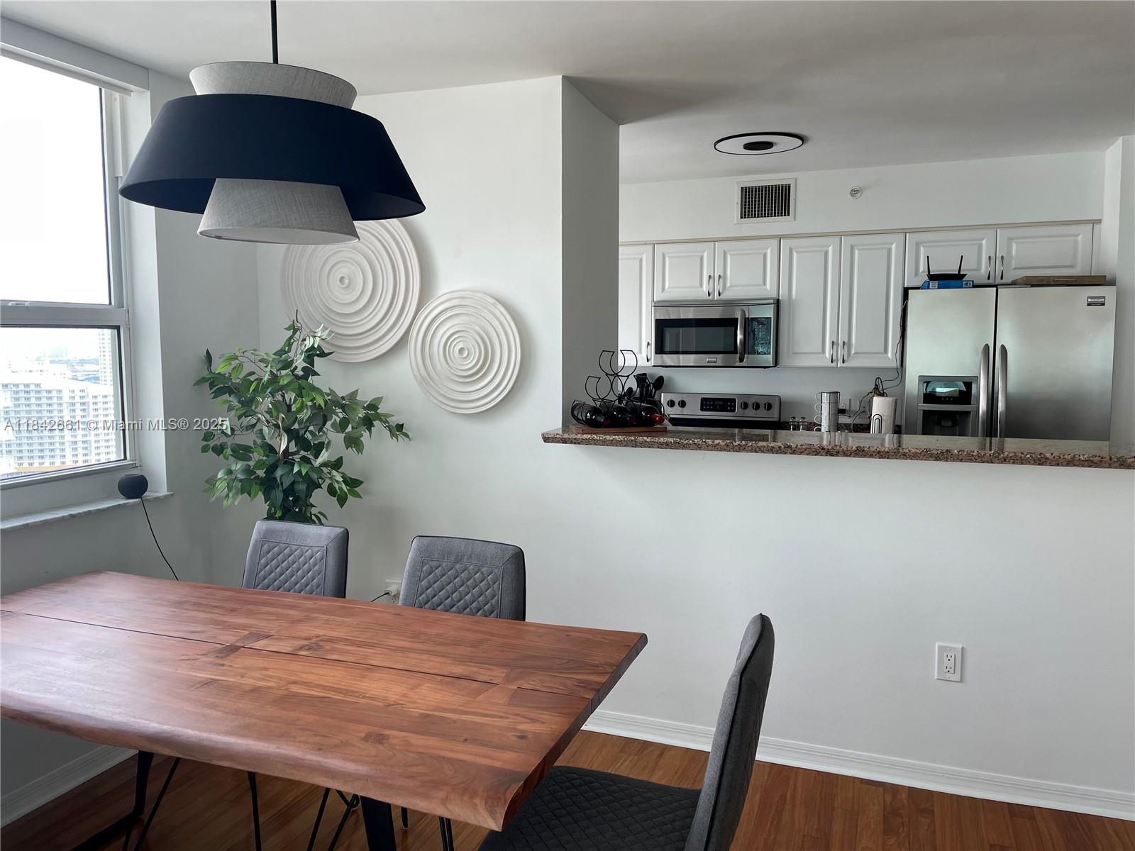 1155 Brickell Bay Drive, Unit 2802 Miami, FL 33131 - Photo 8 of 43 a kitchen with a table and chairs in it