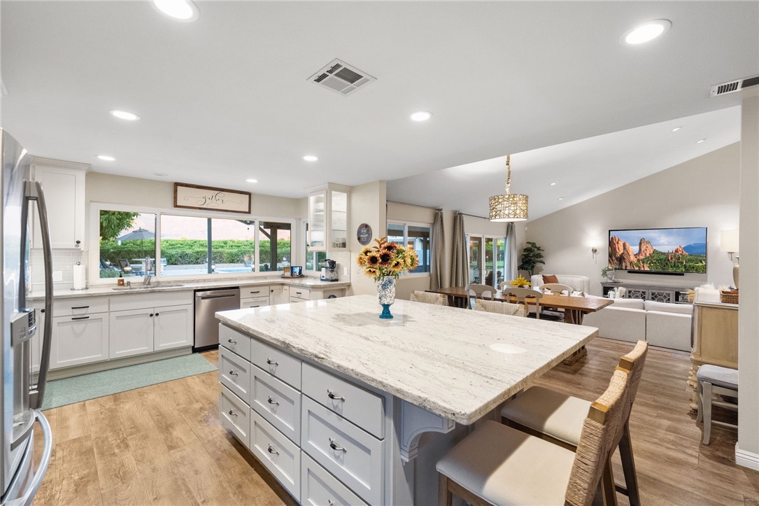 26440 Old Agency Road Hemet, CA 92544 - Photo 18 of 74 a kitchen with a stove a refrigerator and a dining table with wooden floor