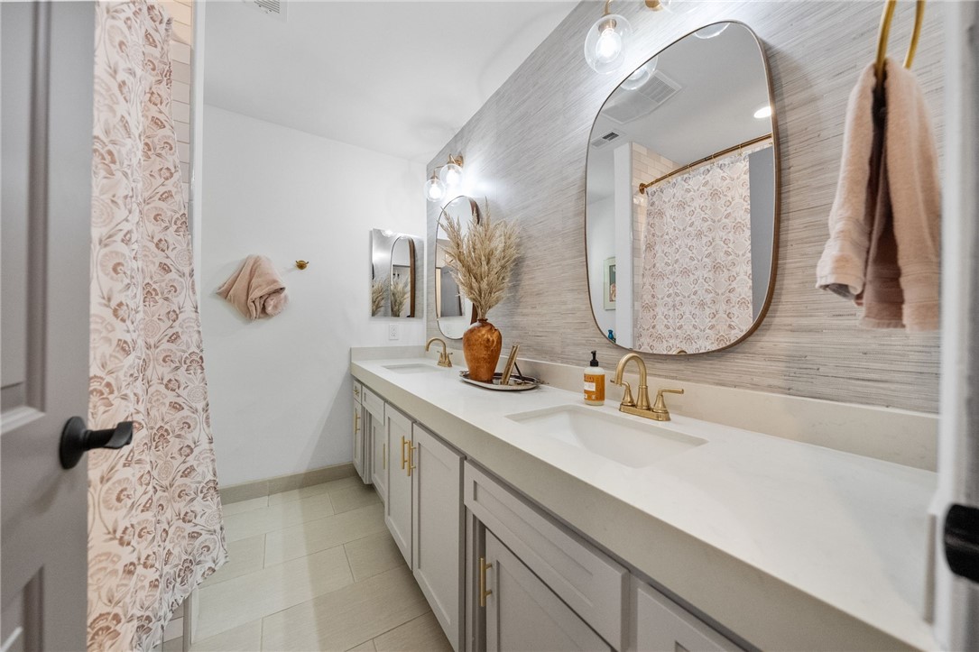 26440 Old Agency Road Hemet, CA 92544 - Photo 44 of 74 a bathroom with a double vanity sink and a mirror