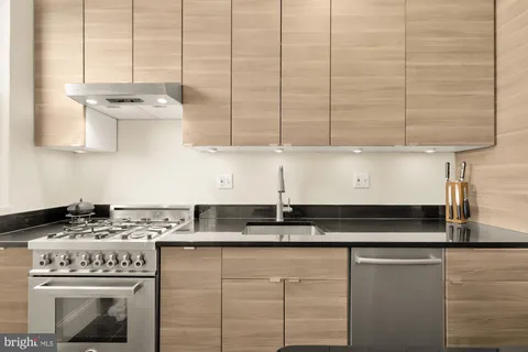 a kitchen with stainless steel appliances granite countertop a sink a stove and a cabinets