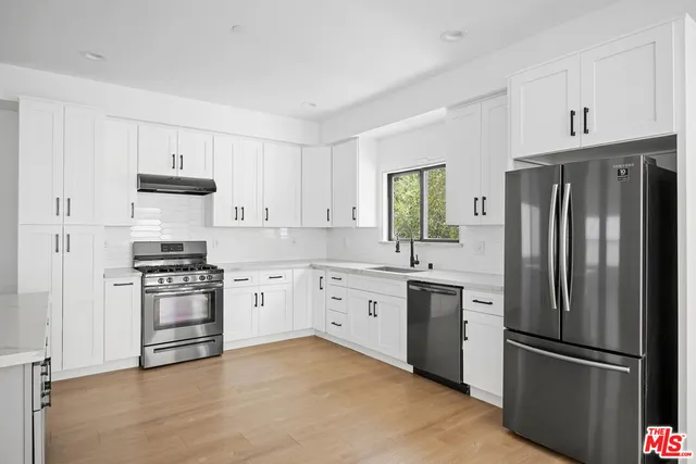 a kitchen with cabinets stainless steel appliances and a window