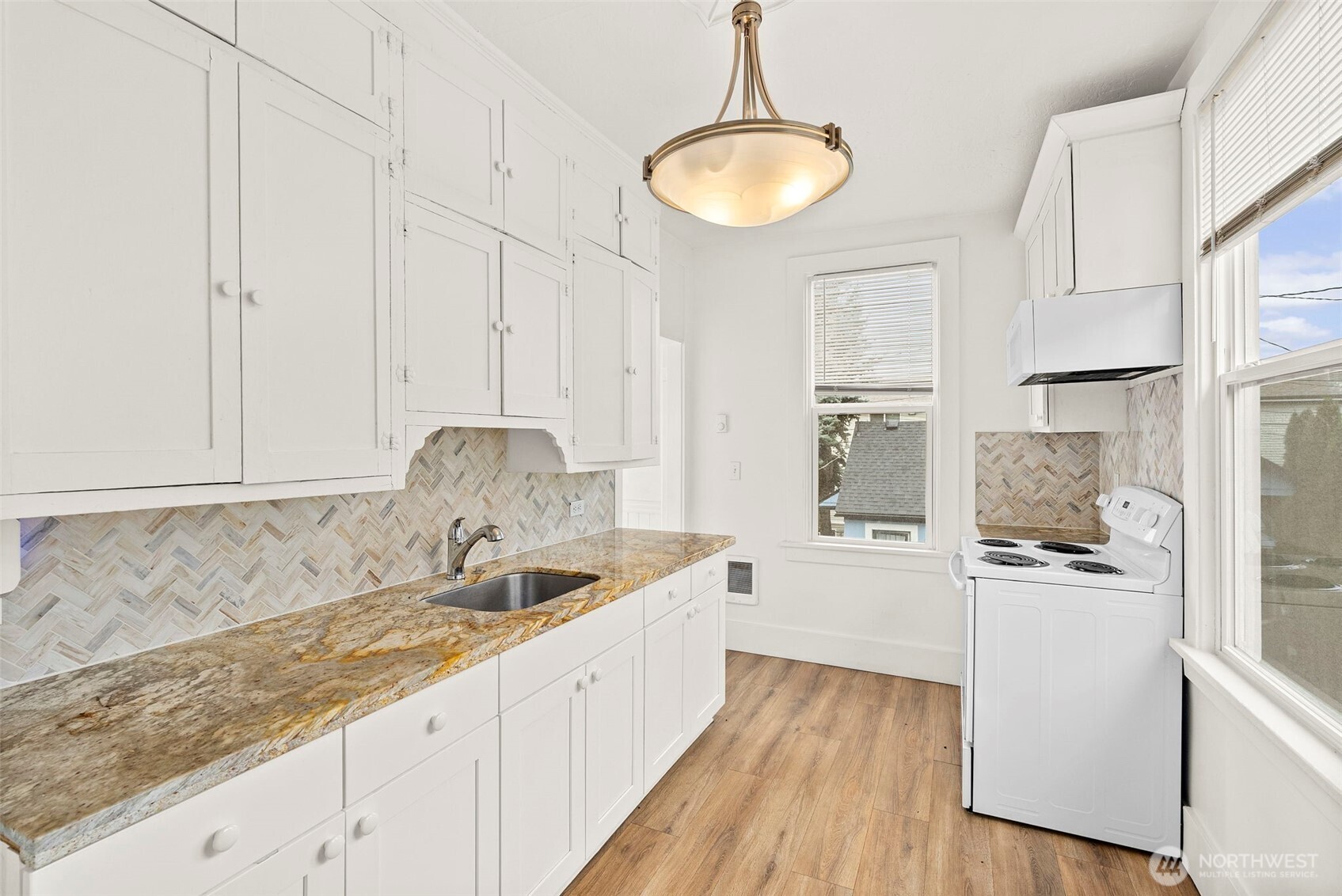 409 South 30th Street Tacoma, WA 98402 - Photo 14 of 37 a kitchen with granite countertop white cabinets and white appliances