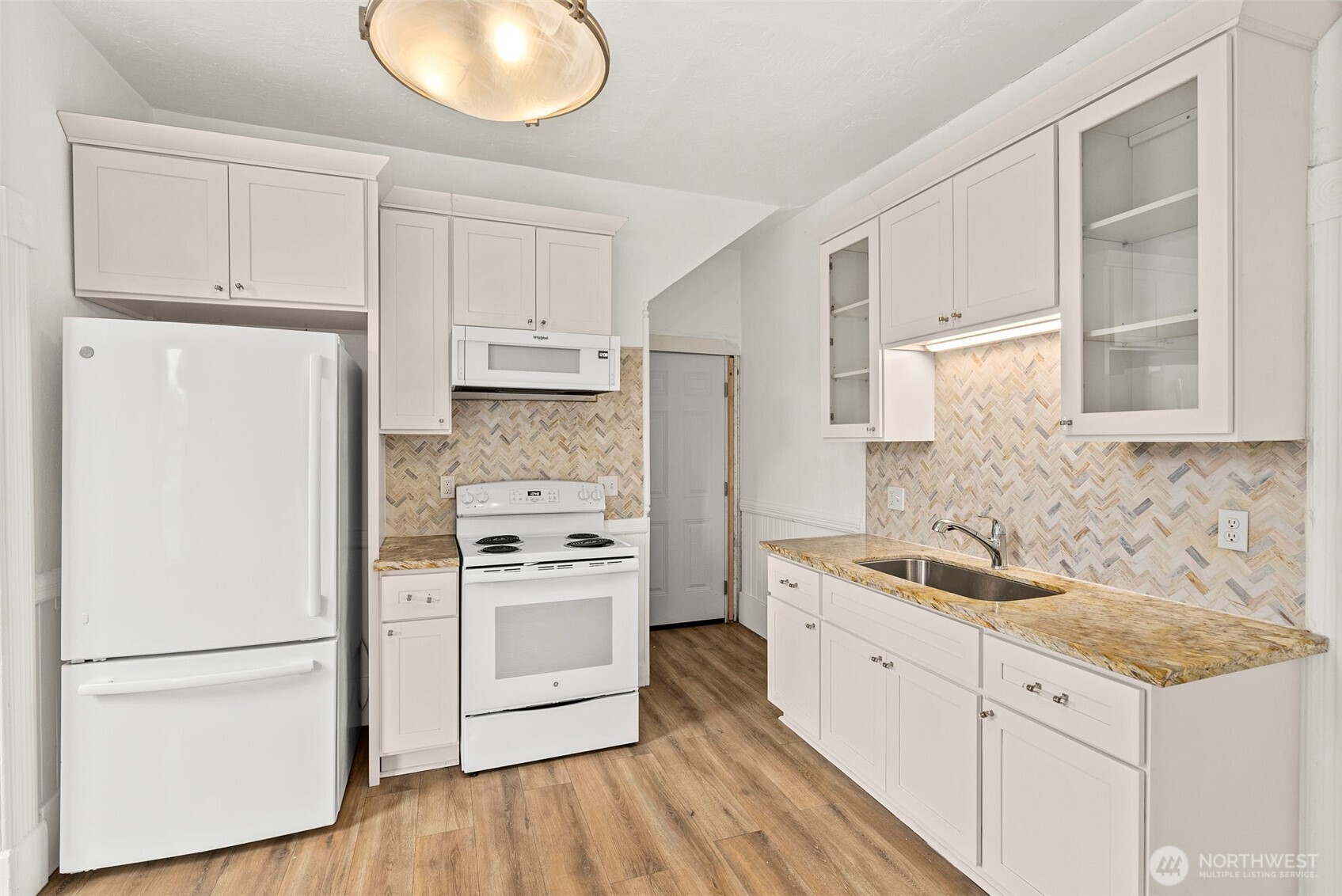 409 South 30th Street Tacoma, WA 98402 - Photo 24 of 37 a kitchen with white cabinets and white appliances