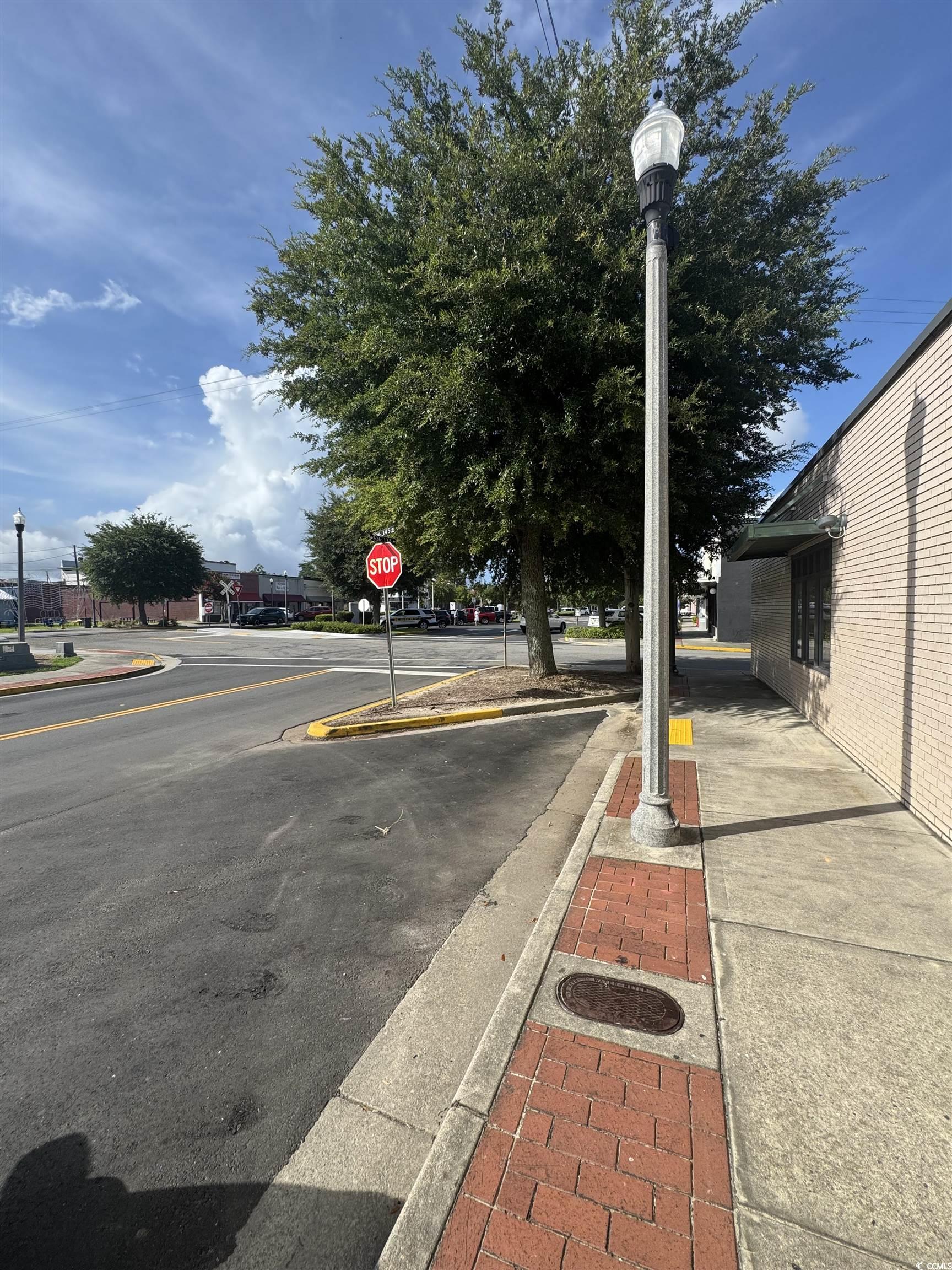 4211 Meeting Street Loris, SC 29569 - Photo 21 of 22 View of asphalt street featuring sidewalks, street lights, curbs, and traffic signs