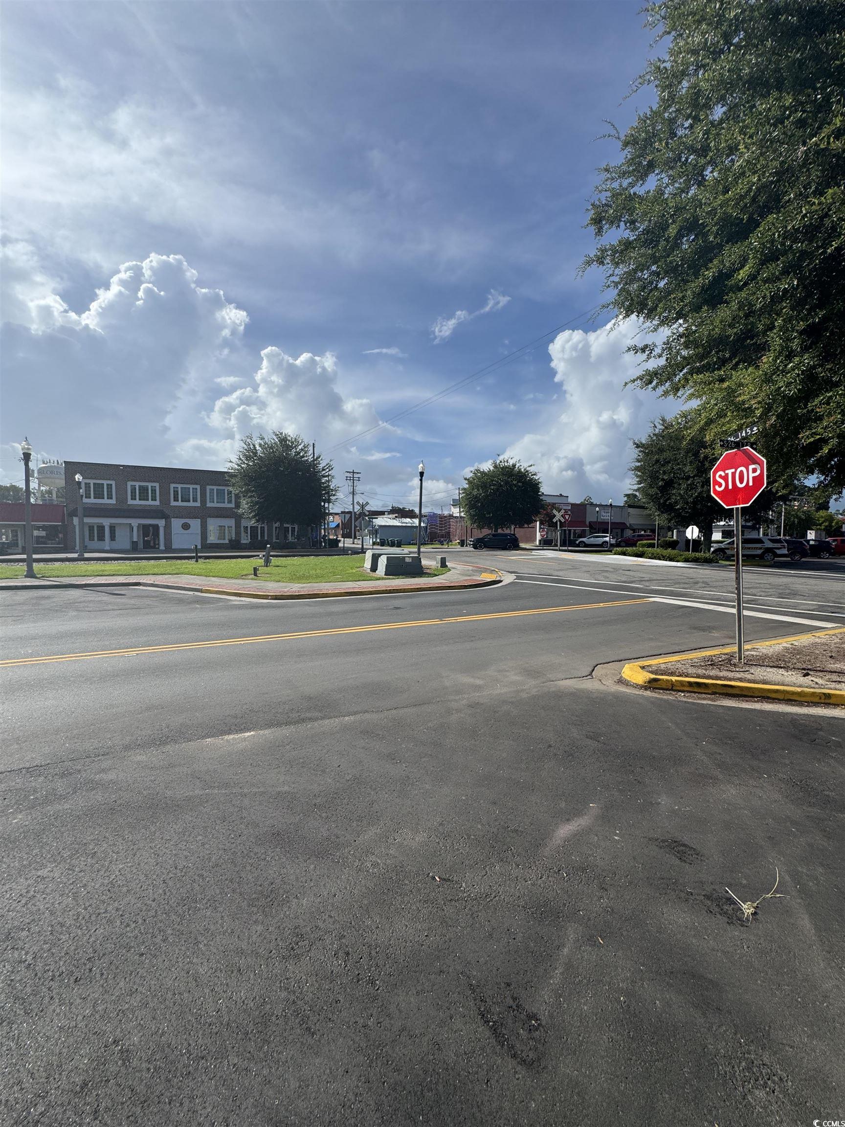 4211 Meeting Street Loris, SC 29569 - Photo 22 of 22 View of asphalt road featuring curbs, traffic signs, and sidewalks