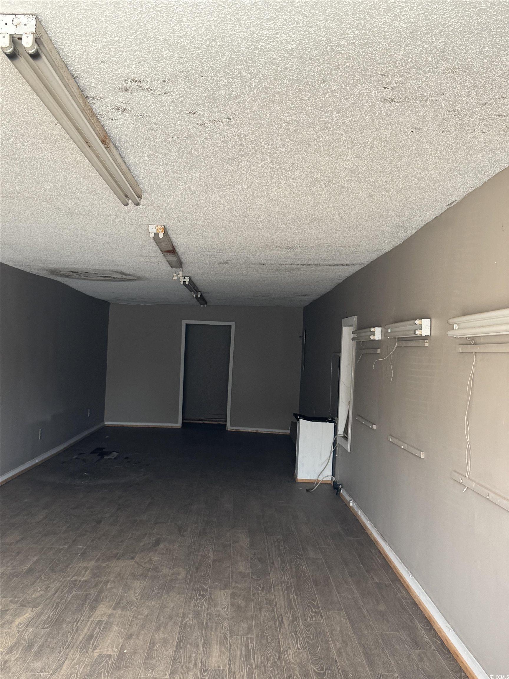 4211 Meeting Street Loris, SC 29569 - Photo 7 of 22 Empty room with dark wood finished floors and a textured ceiling