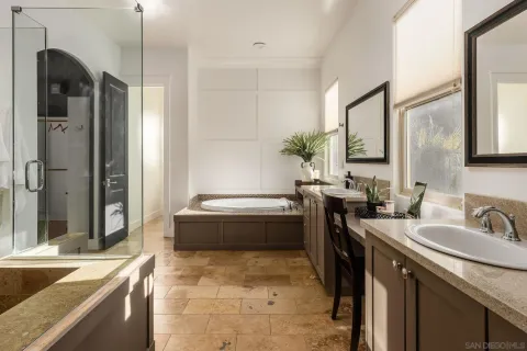 a spacious bathroom with a tub sink and mirror