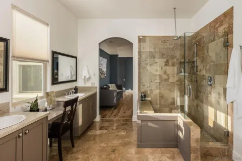a bathroom with a double vanity sink a toilet a mirror and shower