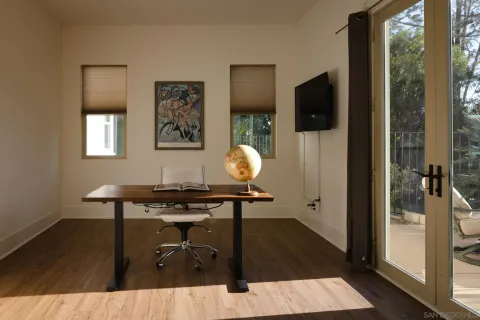 a view of a workspace with furniture and a window
