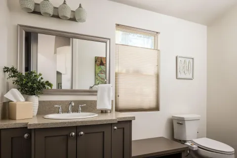 a bathroom with a granite countertop sink a toilet and a mirror
