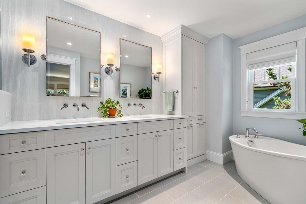 29 Royce Road Newton, MA 02459 - Photo 18 of 38 a bathroom with a double vanity sink a large mirror a bathtub and