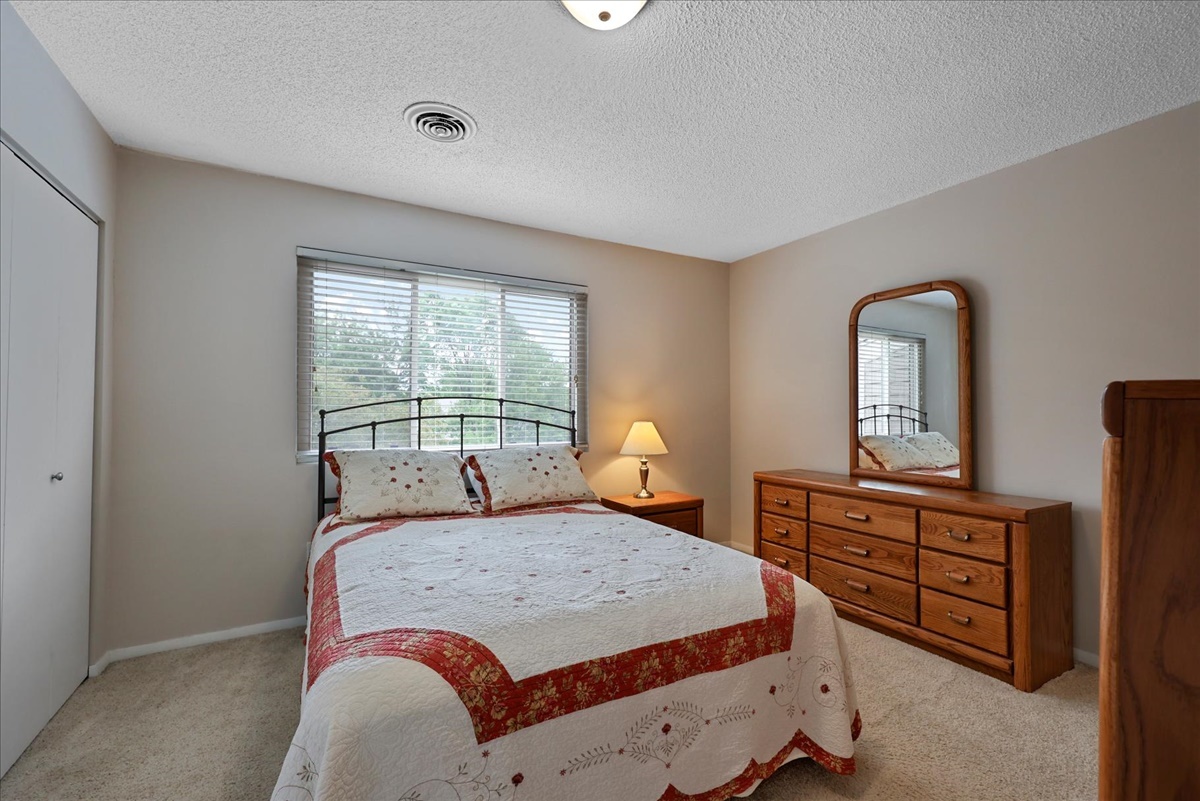 2004 Blackthorn Drive Champaign, IL 61821 - Photo 17 of 24 a bedroom with a bed and dresser with mirror