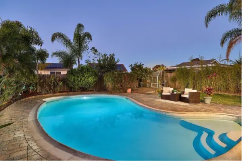 a view of a swimming pool with a house in the background