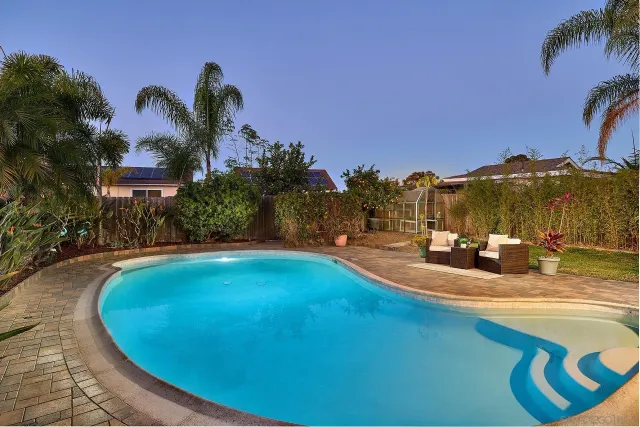 a view of a swimming pool with a house in the background