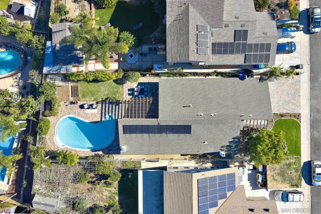 an aerial view of a house with a yard and seating space
