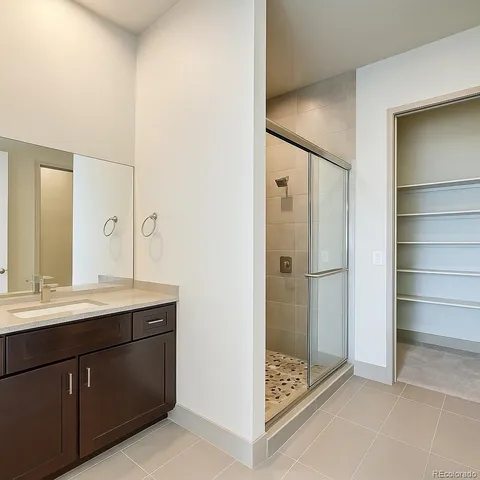 a bathroom with a shower sink and mirror