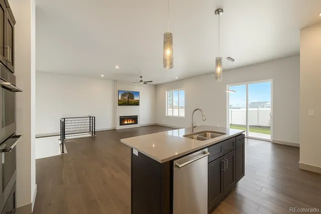 a kitchen with stainless steel appliances granite countertop a sink a stove and a refrigerator
