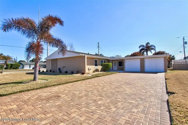 a front view of a house with a yard and tree s
