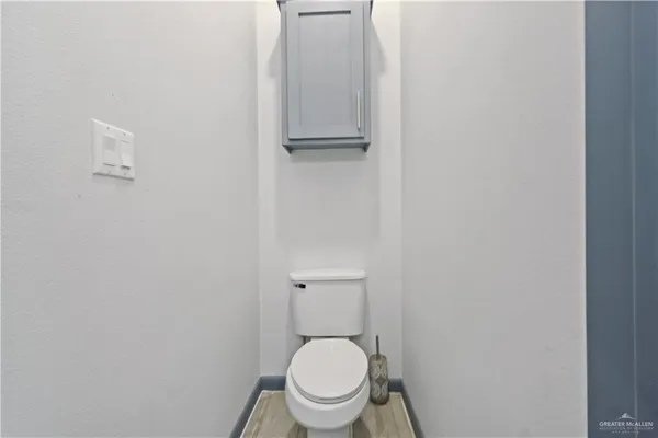 a white toilet sitting in a bathroom next to a sink