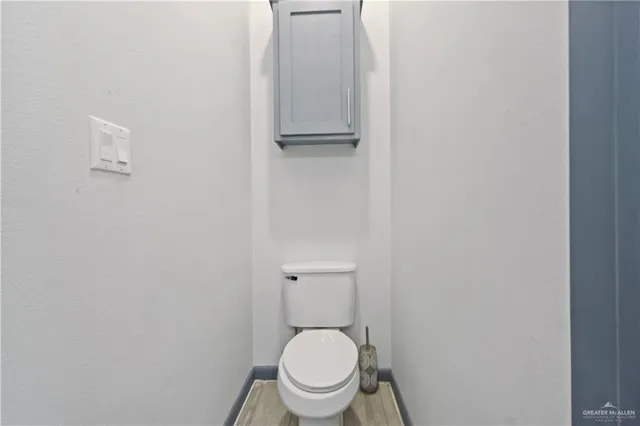 a white toilet sitting in a bathroom next to a sink
